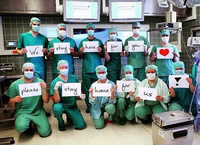 Medical staff in scrubs and masks: We stay here for you. Please stay home for us!